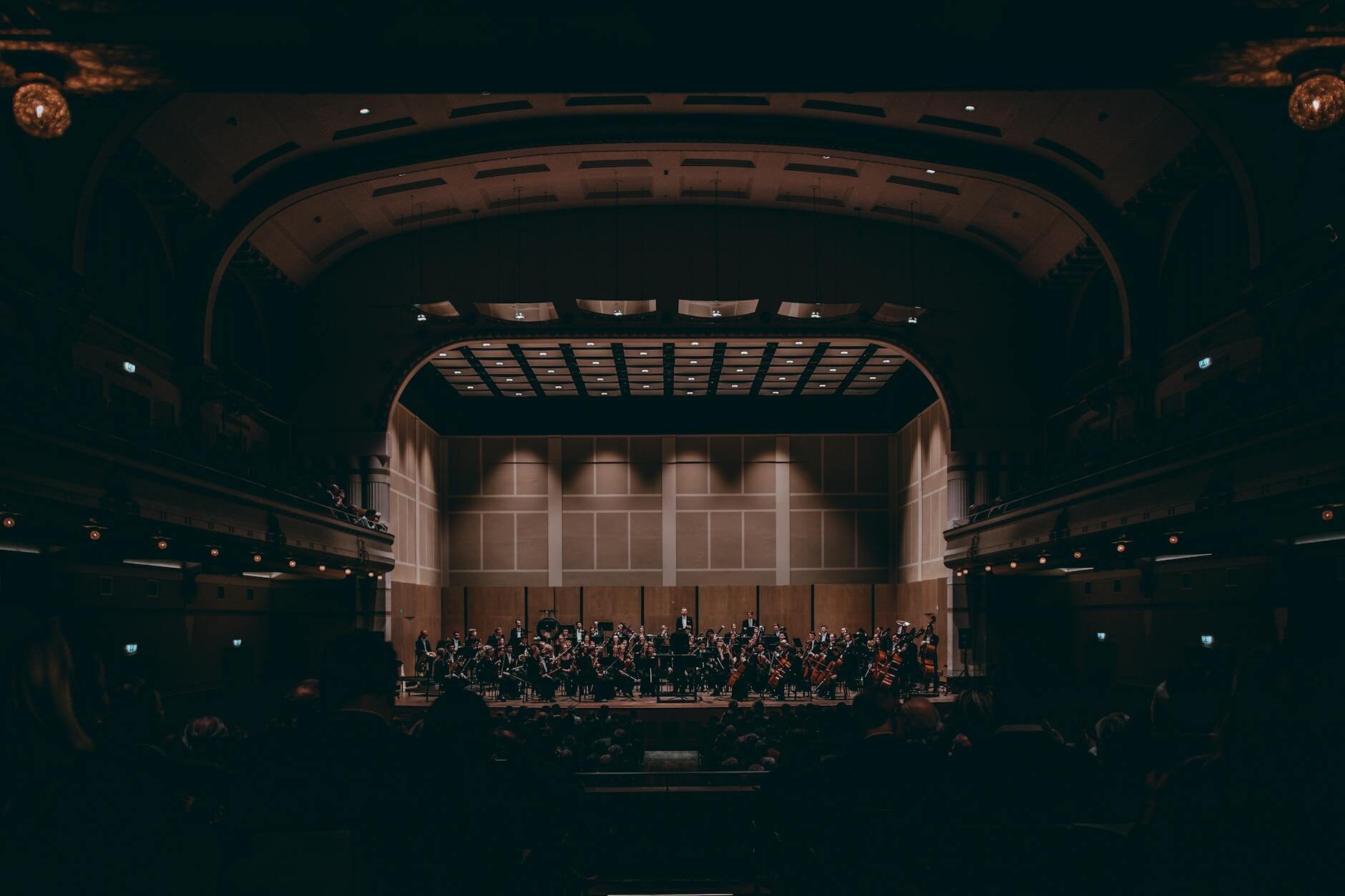 Full symphony orchestra performing on a grand concert hall stage